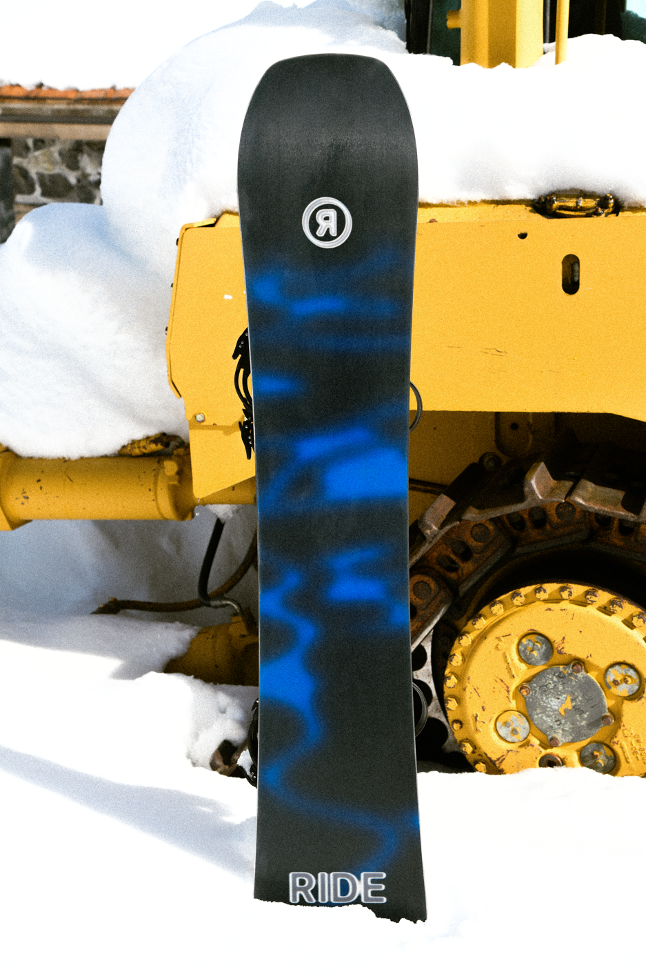 Ride Current Snowboard 2027 with bold base design, ideal for snowboarding adventures, shown on a lifestyle background.